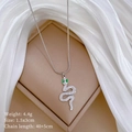Detailed view of silver snake necklace pendant with green eyes and white zircon stones - Silver