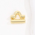 Detailed macro view of a glossy gold Libra zodiac pendant with a polished mirror finish - Libra