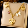Macro detail of gold-plated stainless steel chain with heart charms and white bow pendant - Sacred Heart Bow Style (N3227)