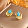Detailed close-up of 18K gold earrings featuring blue turquoise stones on golden box - Gold + Deep Blue Turquoise