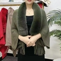 Detail of dark green knit shawl featuring a plush faux fur collar and long fringe trim - Green