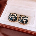 Close-up of golden square earrings with black leopard print enamel inlay in jewelry box - Gold (Silver Earring Post)
