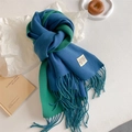 Detail of soft knit scarf in blue and green color block with tassel fringes and label - Peacock Blue