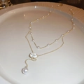 Elegant double layer gold necklace with white rose pendant and pearls on white ceramic plate - Pearl Camellia Flower Double Layer Necklace