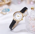 Detail view of a vintage gold watch with black leather strap on a pearl crown display - Black