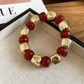 Détail de perles carrées en métal doré et perles en résine rouge translucide sur le bracelet - Rouge