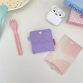 Detail of purple quilted heart pattern pouch with pink heart button and brand label - Purple Heart