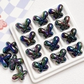 Macro shot of colorful aurora butterfly beads with metallic luster on white grid tray - 24*18mm / Black