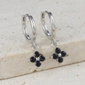 Macro detail of S925 sterling silver huggie earrings with black clover flower charms - Silver-Black