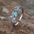 Detail of olive branch ring featuring blue opal leaves and zircon accents on stone - US 6 / Platinum Blue Opal