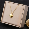 Dettaglio di una collana a cuore dorata presentata in una scatola regalo beige - Ciondolo a Cuore (26A06011-9) / Oro