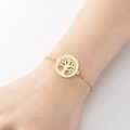 Elegant gold chain bracelet featuring a circular Tree of Life cutout pendant on wrist - 352-Tree of Life