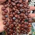 Macro shot of polished reddish-brown waterdrop natural stone beads for DIY jewelry - 10mmx12mm / Natural Red Jasper