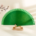 Minimalist green solid wood folding fan displayed on a wooden stand for decoration - Green