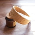 Close-up of a woven raffia headband showing intricate texture on a glass jar - Khaki Solid Wide Edge