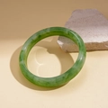 Detail of green resin bangle with marble texture resting on a textured stone base - Green-Large