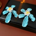 Detailansicht der blauen Emaille-Blumenohrringe mit Perlenmitte auf Lederbox - Stil mit Silber-Ohrstecker / Blau