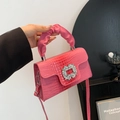 Pink crocodile-embossed handbag featuring a large crystal buckle and gathered handle detail - Pink