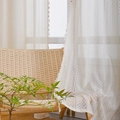 Beige lace curtain with geometric weave and fringe trim hanging by a rattan chair - Wabi-sabi Style White Gauze (Grommet Top) / W140*H160
