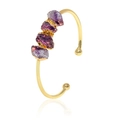 Detail of a gold plated open cuff bracelet featuring four irregular raw purple crystals - Four Amethyst Stones Bangle