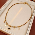 Dettaglio di collana boho con perline e ciondoli a sole e stella in scatola regalo - Oro-Marrone