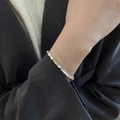 Close-up of minimalist faceted silver bead bracelet worn on a female wrist with a suit - Silver Polyhedron Ultra-Fine (MY30312)