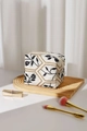 Detail view of cotton linen makeup bag featuring floral embroidery and gold chain details - Black Leaf Pillow Bag