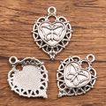 Silver Halloween heart pendant with butterfly relief shown on a wooden background - 27B2-7 Butterfly Heart