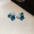 Detalle de pendientes de flores de cristal azul con perlas sobre tela beige - Perno de plata-Azul
