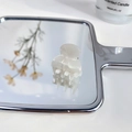Mini pearl white acetate hair claw clip for girls shown on a reflective vanity mirror - AB White