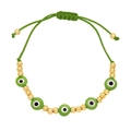 Detailed view of handmade green braided evil eye bracelet with gold metallic bead accents - Green