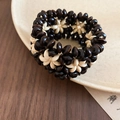 Dettaglio macro di perline etniche in guscio di cocco e design di bracciale in legno - Stile con motivo a fiori bicolore