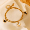 Pulsera de doble capa de acero inoxidable dorado con dijes de mariposa sobre satén suave - Tobillera / Dorado
