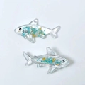 Detail of transparent shark resin pendants with blue stones and gold foil flakes inside - Light Blue Shark