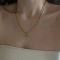 Detailopname van gouden Figaro-ketting met moderne T-bar-sluiting gedragen door model - 3mm Figaro Ketting