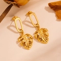 Detalle de pendientes dorados con forma de hoja y piedras pequeñas en fondo beige - Pendientes de Hoja de Monstera Dorada (G512)