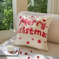 Merry Christmas red embroidered tufted pillowcase on a cozy white sofa setting - Chenille Star Christmas Letter
