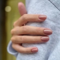 Glossy dusty pink press-on nails in medium square shape shown on hand for women - Nude Pink