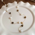 Detail view of tiger eye beads and pearls necklace on a white decorative ceramic plate - 27# Necklace-Gold-Brown-10mm (Tiger Eye Pearl)