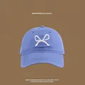 Close-up of blue cotton baseball cap showing detailed white butterfly embroidery on front - Front Bowknot Embroidery Baseball Cap / Navy Blue