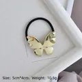 Detail of golden butterfly hair tie with size dimensions 5cm x 4cm and weight 10.5g - Gold Glossy Butterfly