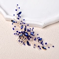 Exquisite bridal hair comb with deep blue crystals and gold wire on a textured background - Royal Blue