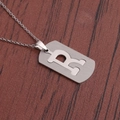 Vue détaillée du collier en acier inoxydable avec pendentif lettre R sur bois brun - Lettre R