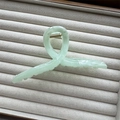 Close-up of a pale green translucent ink painting hair claw clip with a gold metal spring - Green Cross 13cm