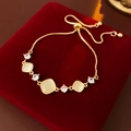 Close-up of golden adjustable chain bracelet with yellow cat eye stones and zircons - Gold