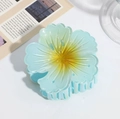 Close-up of a gradient blue and yellow frangipani hair claw clip with a transparent resin finish - Plumeria Claw Clip Blue