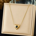 Detalle de un collar de corazón dorado con gema negra sobre un joyero elegante - Estilo Negro (N3976)