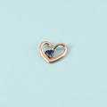 Détail d'un pendentif cœur en or rose avec une pierre bleue et un design ajouré élégant - Couleur Or Rose Septembre