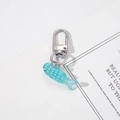 Close-up of a blue translucent resin fish keychain with white dots and silver clasp - Whale