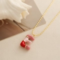 Détail du collier chaîne dorée avec pendentif lettre F en émail rouge et rose - Style-E